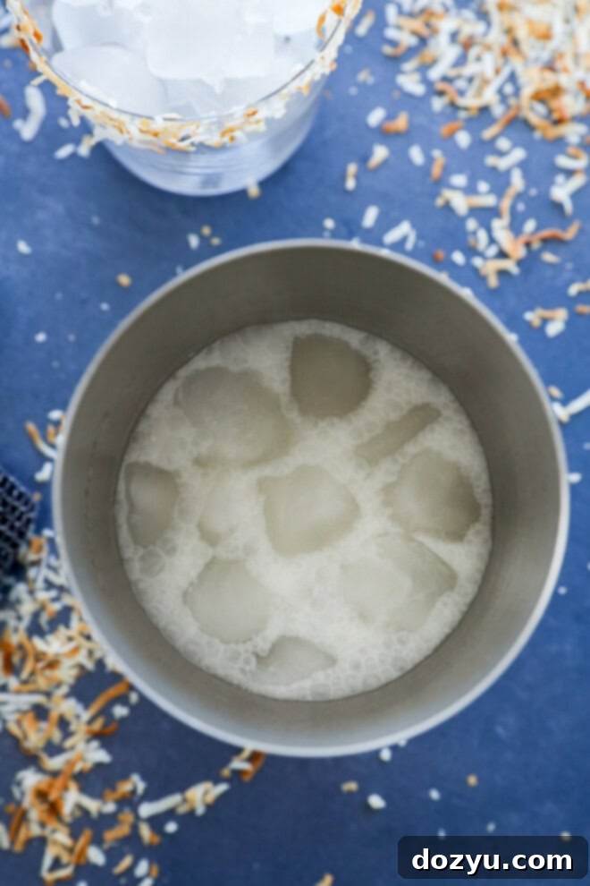 Mixing a Coconut margarita cocktail in a shaker with ice and ingredients