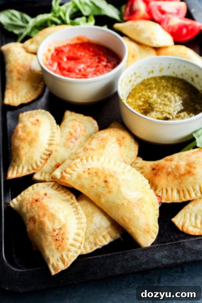 Flawless Empanada Dough Made Easy 2 easy pastries on sheet pan with dipping sauces and tomatoes and basil