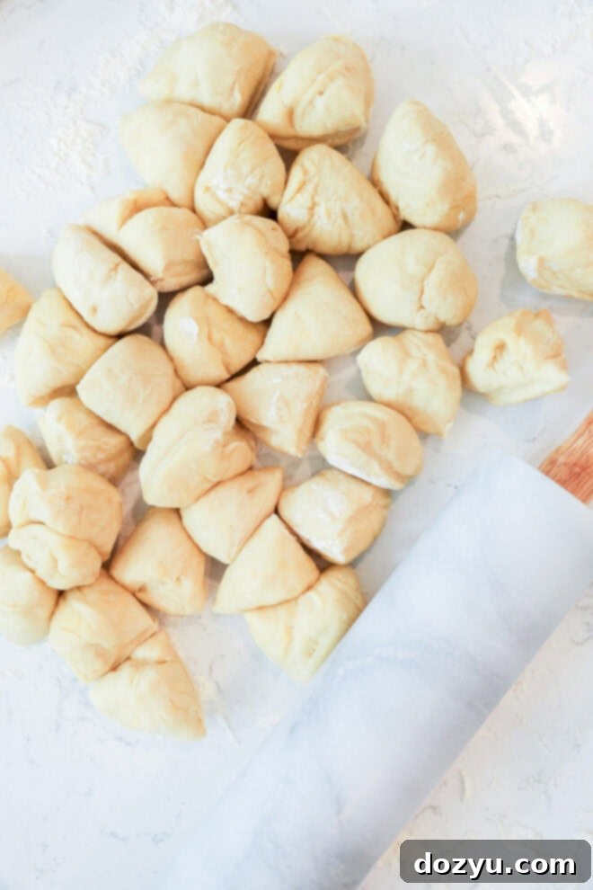 Flawless Empanada Dough Made Easy 5 empanada dough balls next to rolling pin on marble