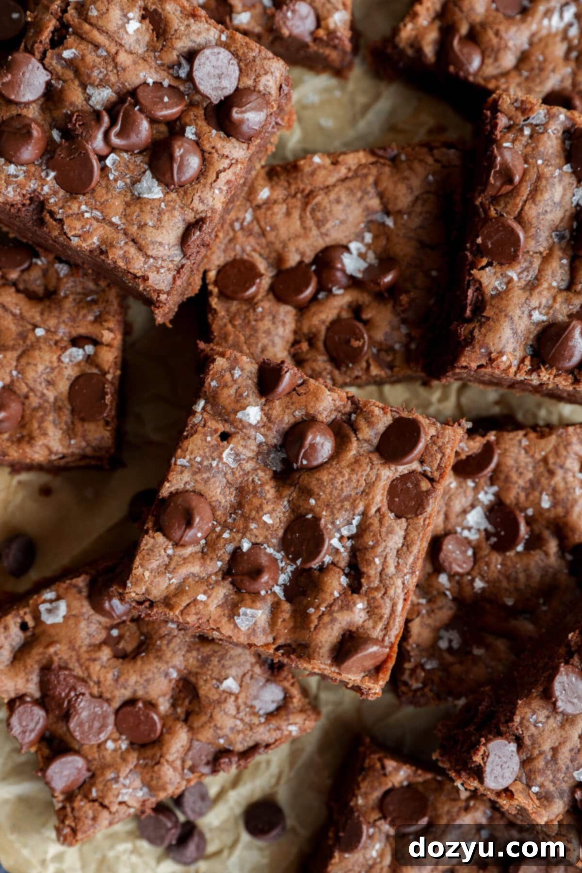 pile of chocolate chocolate chip cookie bars on brown parchment paper