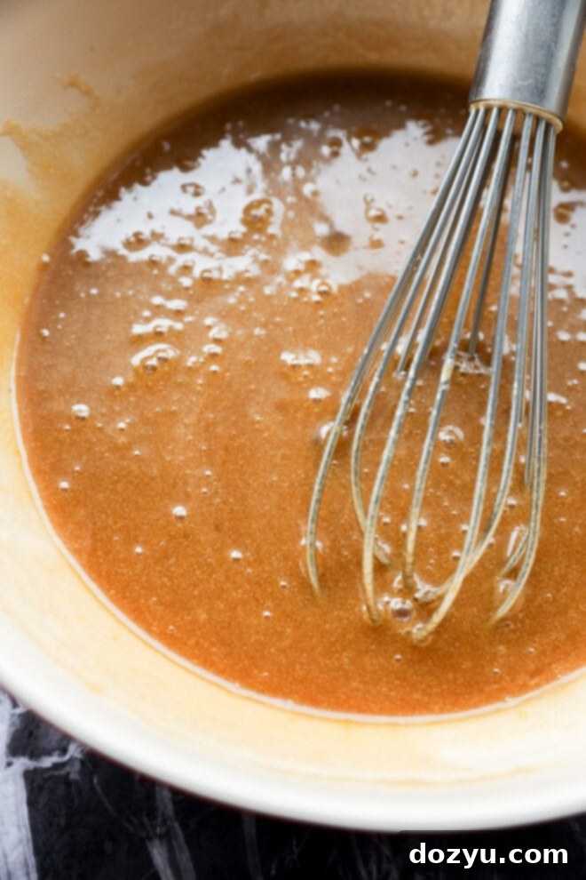 mixing together wet ingredients in a bowl with a whisk