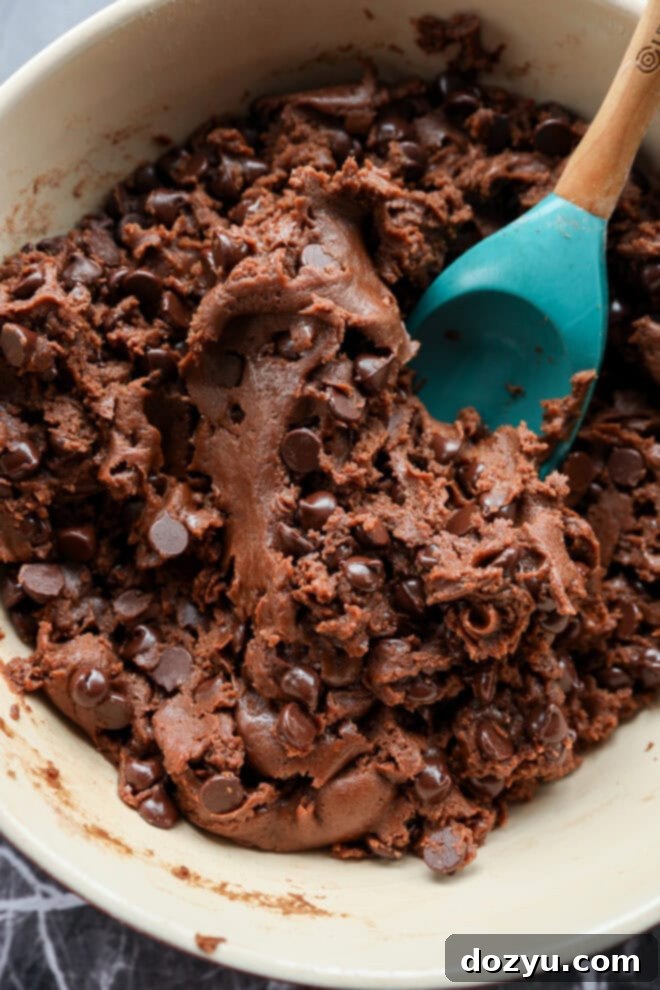 chocolate chocolate chip cookie bar batter in bowl with spatula