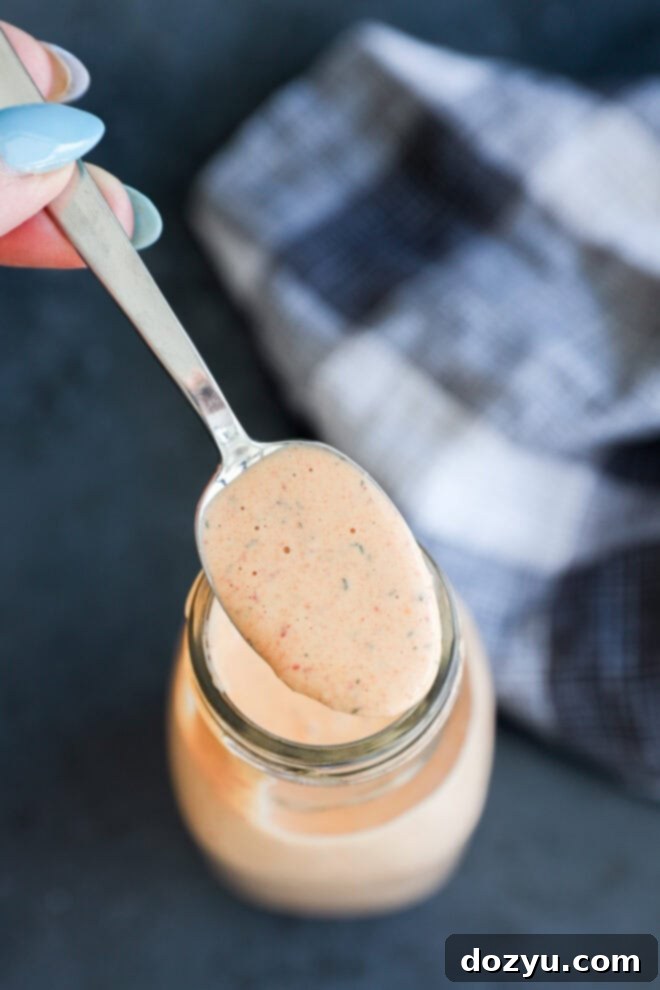 Spooning out chipotle ranch salad dressing from a glass jar