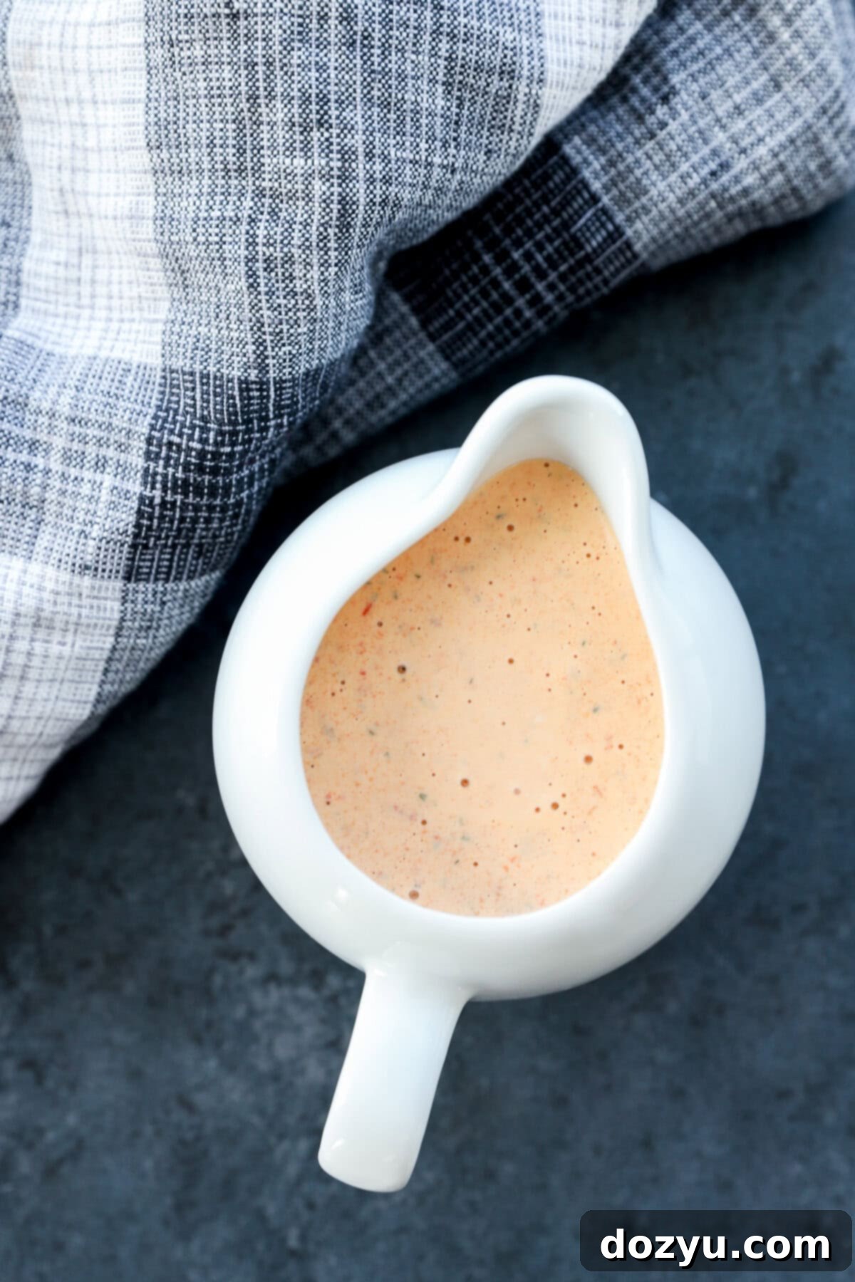 chipotle ranch salad dressing in a pouring vessel that is white and with linen
