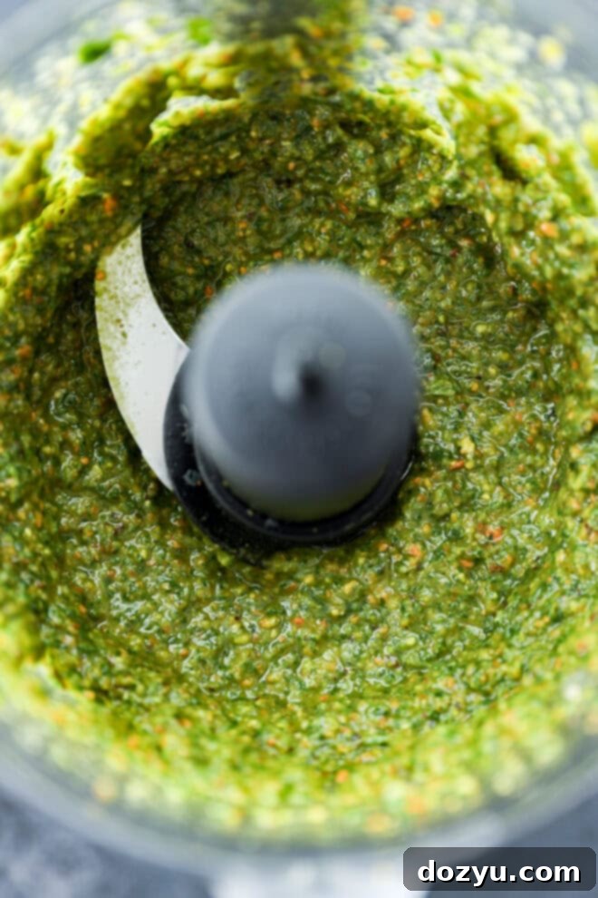 Vibrant Pistachio Pesto 5 Vibrant green pistachio pesto blended to a creamy consistency inside a food processor bowl.