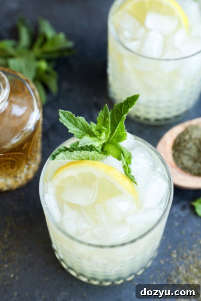 Green tea cocktail in glasses with fresh lemon slices and mint leaves in them
