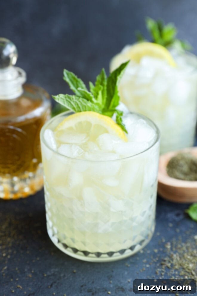 green tea cocktail in rocks glass with syrup in back and green tea