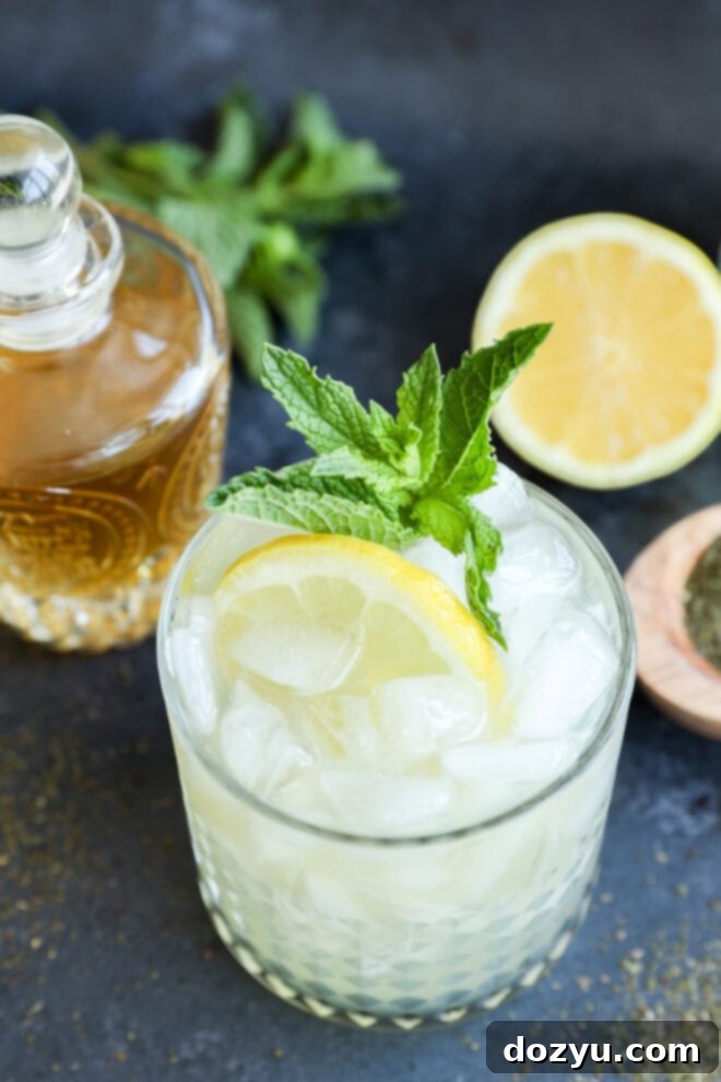 Green tea cocktail over ice with fresh mint and a lemon slice