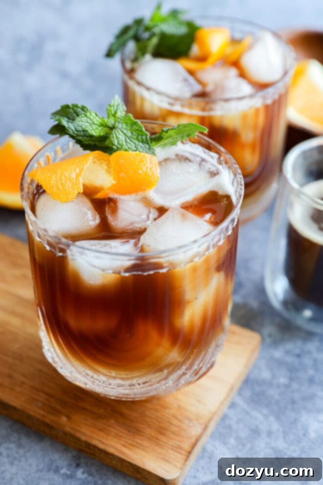glasses of iced coffee with mint sprigs and orange peel