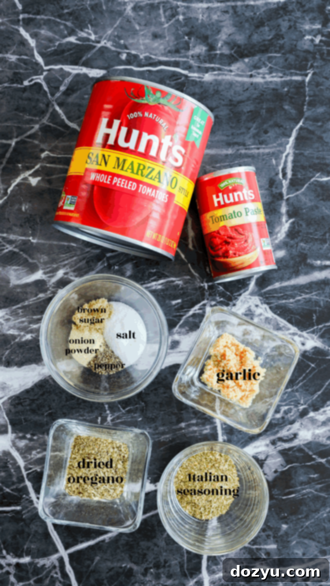 The Ultimate Pizza Sauce 3 Two cans of Hunt’s tomatoes (whole peeled and tomato paste), essentials for the Best Pizza Sauce, on a marble surface, surrounded by glass bowls with salt, brown sugar, onion powder, garlic, dried oregano, and Italian seasoning.