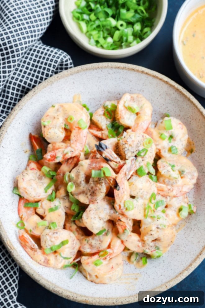 Grilled bang bang shrimp in a bowl with green onion sprinkled on top