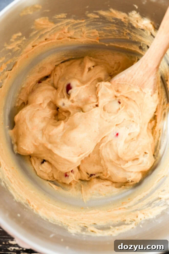Orange cranberry muffin batter in a mixing bowl.