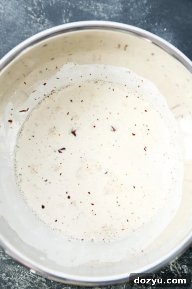 Chocolate and cream in a metal mixing bowl.