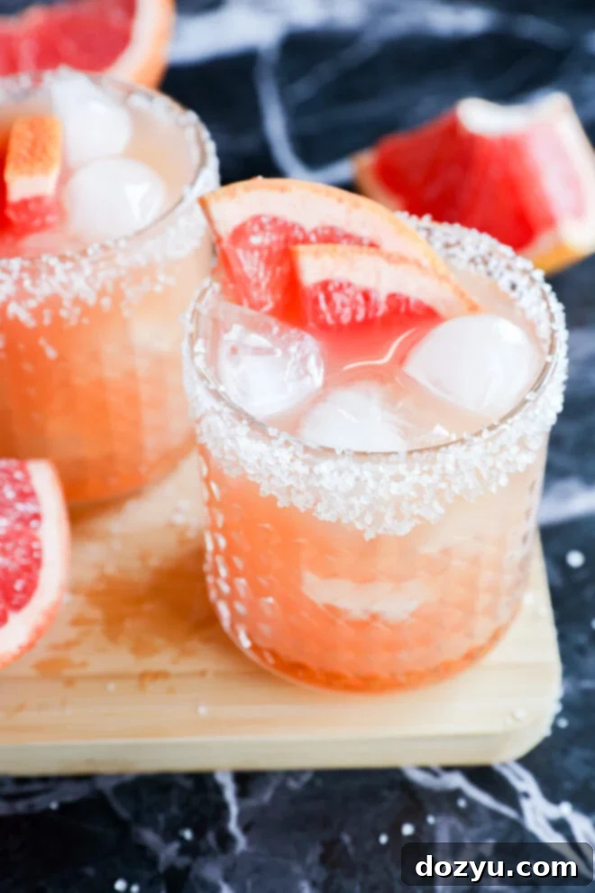 Two glasses with salt-rimmed edges are filled with a refreshing drink and elegant touch.