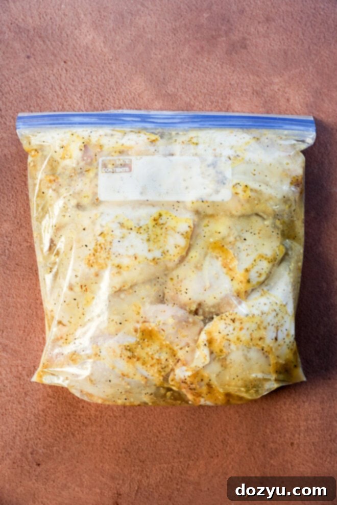 Lemon Herb Roasted Chicken and Potatoes 6 A clear ziplock bag filled with raw chicken pieces marinating