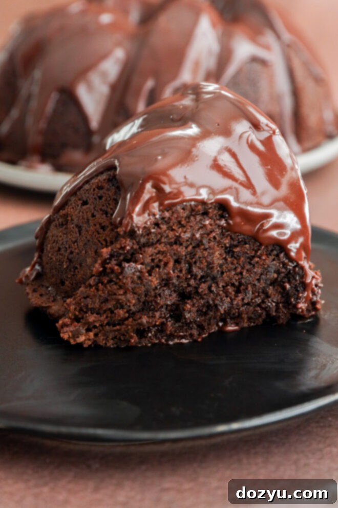 A slice of chocolate brownie cake on a black plate.